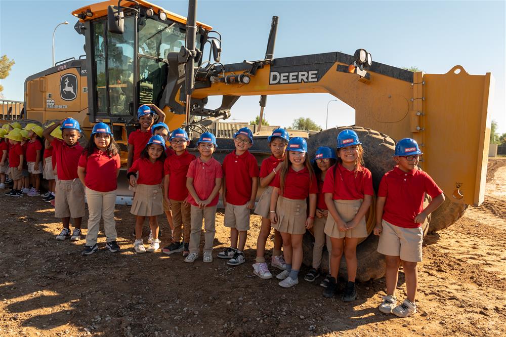 Students stand by a bulldozer